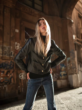 a lady wears a black leather jacket with jeans